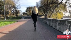 Blond Ukraine woman in black high heels boots and black coat