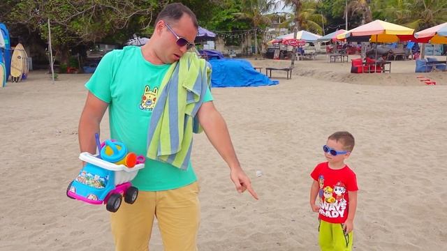 Сабый и сонный папа играют на пляже.
