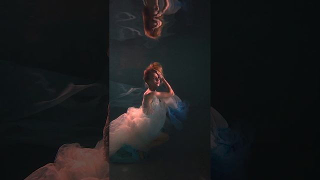 A beautiful girl dances underwater in a white dress and with a flying cloth. underwater videography