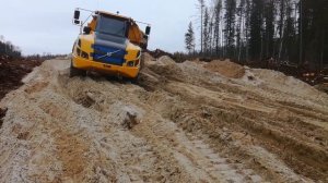 Отсыпка первого слоя дороги на подъем к кусту самосвалами Volvo A35