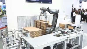 Кобот TM Robot собирает коробки и загружает туда продукцию. Автоматизация упаковки