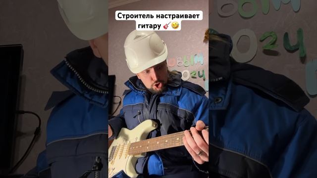 Строитель настраивает гитару