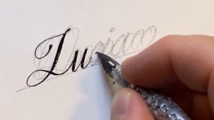 With a Japanese sharp pen, ZEBRA G, I write the name Lucia in calligraphy handwriting.
