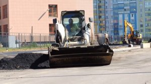 Самосвал высыпал асфальтовую крошку - Бобкэт развозит видео