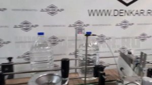 Укупоривание ПЭТ объемом 5Л с последующем нанесением самоклеющейся этикетки.