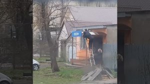 Двое работников Озон устанавливают вывеску для интернет-магазина.Саратов.