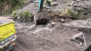 Строительство, грузовик перегружен , экскаватор помогает подняться в гору