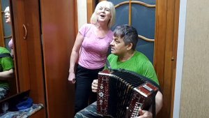 Под окном широким на любительской гармони поет жена и играет муж семейный дуэт