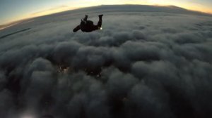 За облаками.