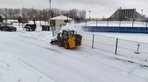 Мини-погрузчик LiuGong CLG 365B с шнекоротором чистит снег в коттеджном поселке