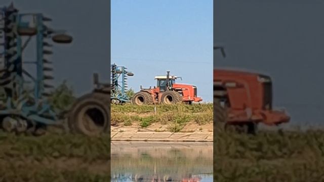 A large tractor is driving to cultivate a field