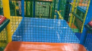 A child jumps on a trampoline and runs on a playground