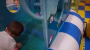 A child on the playground breaks through a wall of bricks and slides down a slide