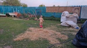 A child runs down the street and jumps in a puddle