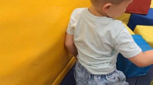 A child runs around the playground, jumps on a trampoline, slides down a hill