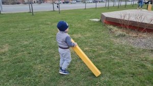 A child plays with wooden blocks on a playground outside