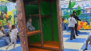 A child plays on a playground crawling through a maze