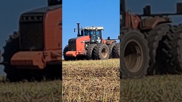 A large tractor is plowing in a field