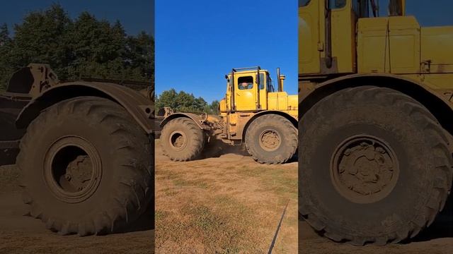 A big yellow tractor is driving along the road