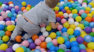 Colored balls on the playground, a child plays on a slide