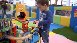A child is running, jumping on a trampoline and sliding down a slide on a playground