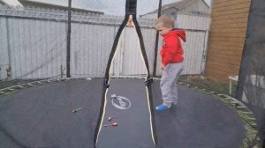 A child jumping on a trampoline in the garden