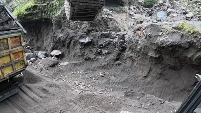 Строительство, экскаватор копает чёрный песок
