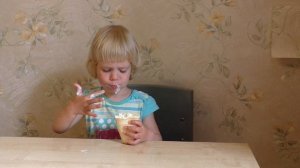 Cute baby eating ice cream cone. Little girl. Маленькая девочка ест мороженое в стаканчике.