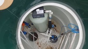 Установка фильтра для воды в круглом пластиковом кессоне