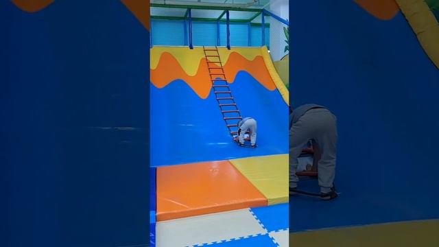 A child slides down a slide on a playground