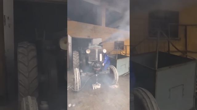 Процесс запуска старинного трактора.