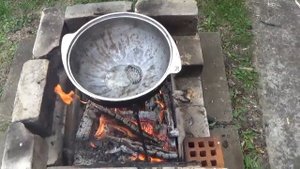 Туристы готовят в лесу в самодельной печи в казане