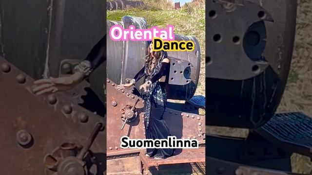 A dancer performs an oriental dance on the carriage of an old gun, Suomenlinna