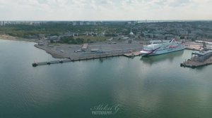 Tallinn port from a drone, an old port crane on the pier and ferries waiting for passengers.