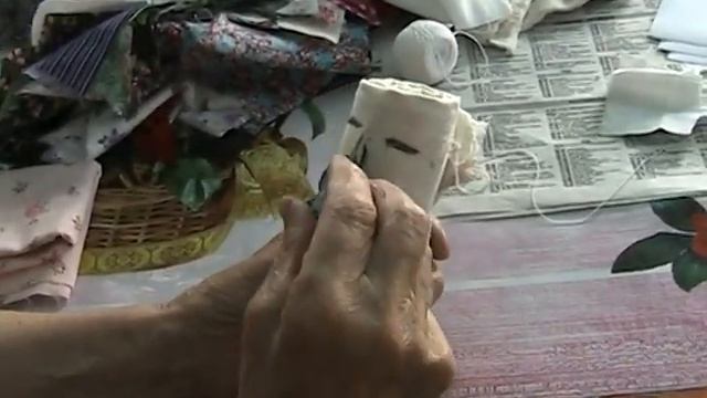 Бабушка рисует лицо кукле