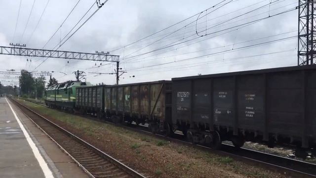 Электровоз 2ЭС4К "Ермак" с грузовым поездом проезжает мимо станции смотреть онлайн