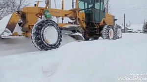 Работа грейдера на расчистке заснеженных улиц.