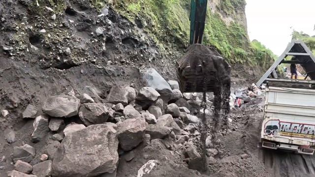 Строительство, экскаватор копает чёрный песок