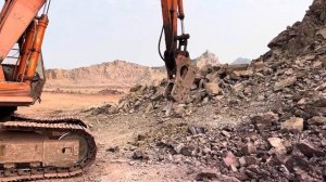 Экскаватор разрушает скалу