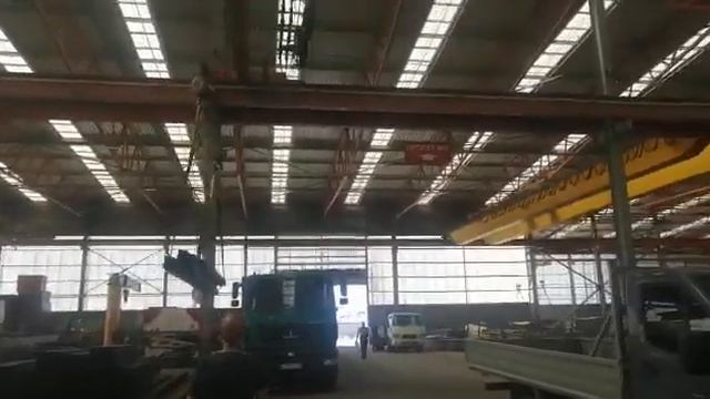 Погрузка верхняя металлопроката в открытый кузов краном на металлобазе.
