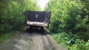 Газель тащит тракторный прицеп через реку