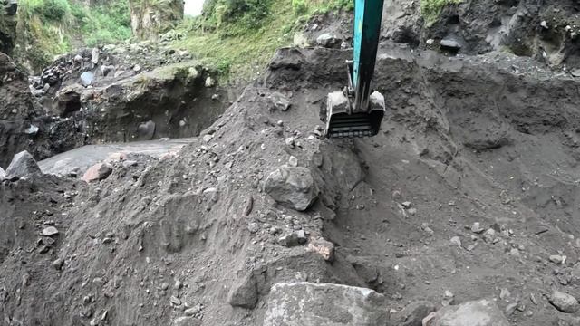 Строительство, экскаватор копает чёрный песок