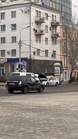 Возле пл. Ленина в Донецке сотрудники полиции помогают отремонтировать сломанный микроавтобус