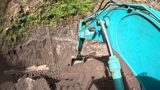 Строительство, экскаватор копает чёрный песок