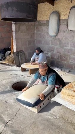 Baking Armenian Lavash bread in traditional oven tonir