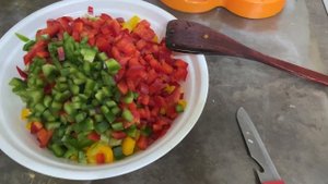 Гречка с тушенкой и овощами в сотейнике на плите.