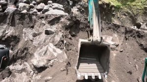 Строительство, много песка и камней в нём, но экскаватор копает хорошо