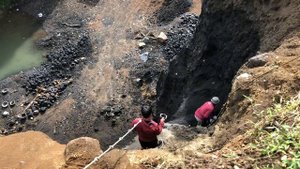 Строительство, вид с утёса , шахтёр сбивает песок