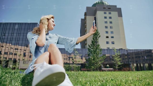 Female student on campus with mobile phone does selfie. смотреть онлайн