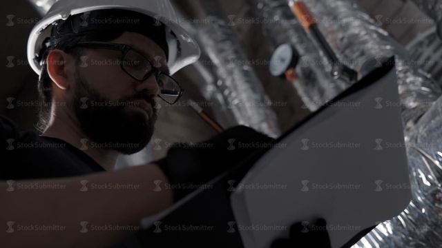 Boiler heating system inspection: man, wearing in helmet makes note смотреть онлайн